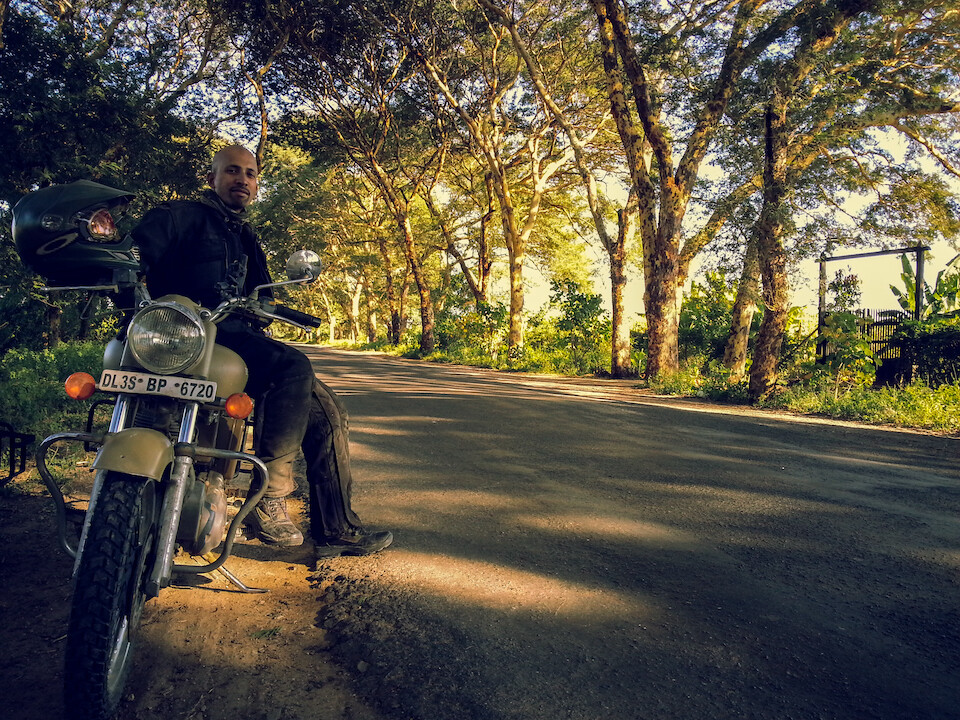 Riding the tree-covered roads from Mandalay to Bagan on a Royal Enfield.